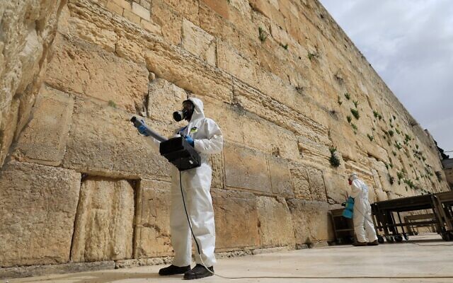 Des employés municipaux désinfectent le mur Occidental, le lieu le plus saint où les Juifs peuvent prier, le 31 mars 2020 en pleine épidémie du COVID-19 à Jérusalem. (Photo par Emmanuel DUNAND / AFP)
