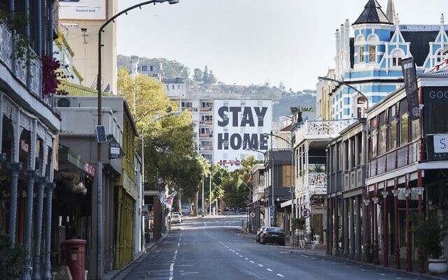 Vue générale de la Long Street, généralement l'un des quartiers les plus animés et les plus populaires du Cap, en Afrique du Sud, avec ses bars, ses clubs et ses restaurants, sous un panneau d'affichage indiquant "Stay Home" (restez chez vous) en plein bouclage dû au coronavirus, le 3 avril 2020. (Rodger Bosch/AFP)