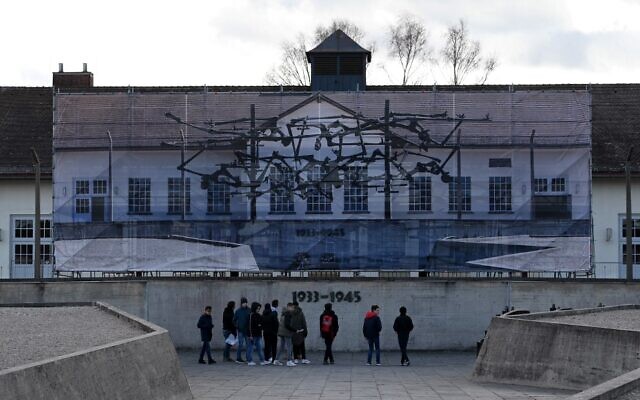 Des visiteurs se tiennent devant le Mémorial international de l'ancien camp de concentration de Dachau, dans le sud de l'Allemagne, le 09 décembre 2019. - L'ancien camp de Dachau, construit en 1933 et qui a servi de modèle à tous les autres camps de concentration en Europe, a été mis à profit par le gouvernement de Bavière, la région dans laquelle il est situé. (Crédit : Christof STACHE / AFP)