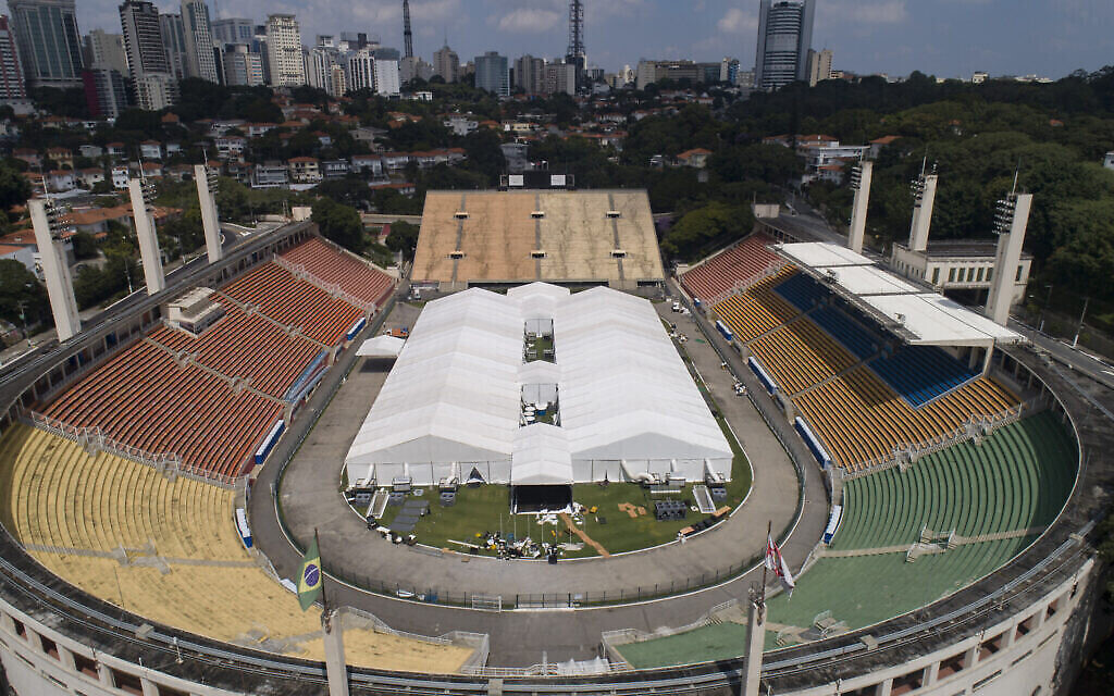 Des employés dressent un hôpital de terrain temporaire pour prendre en charge les malades du COVID-19 au stade Pacaembu de Sao Paulo, au Brésil, le 30 mars 2020 (Crédit : AP Photo/Andre Penner)