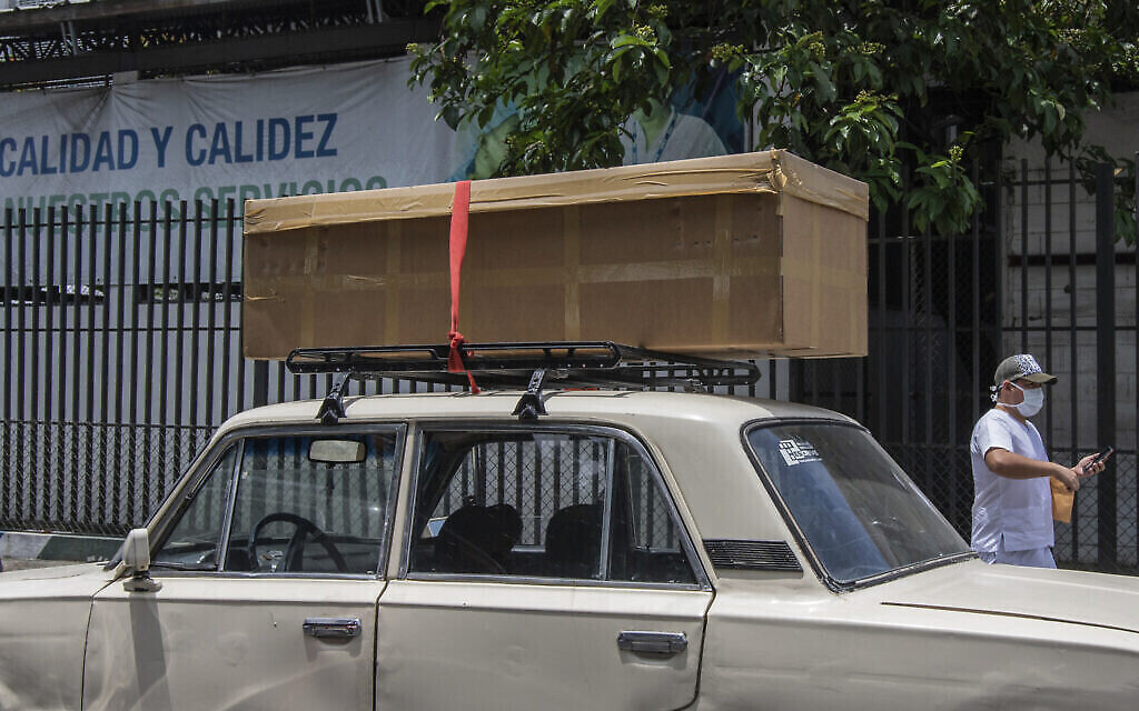 Un cercueil en carton accueillant une dépouille sur le toit d'une voiture avant qu'elle ne soit emmenée pour l'inhumation, aux abords de l'hôpital Teodoro Maldonado de Guayaquil, en Equateur, le 6 avril 2020 (Crédit : AP Photo/Luis Perez)