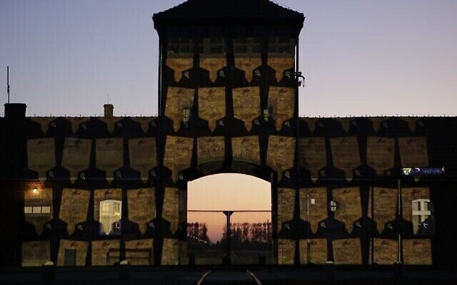 Des plaques mémorielles virtuelles sont projetées sur les portes d'Auschwitz-Birkenau à l'occasion de Yom HaShoah, le 20 avril 2020. (Crédit : Marcin Kozlowski/Marche des vivants)