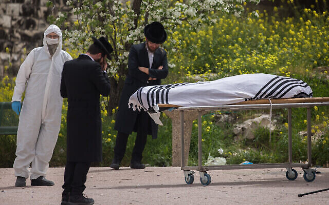 Un petit groupe formé de membres de la famille et d'amis lors des funérailles du rabbin Ben-Zion Cooperstock, décédé des suites des complications d'une infection au coronavirus, à la maison funéraire Shamgar de Jérusalem, le 5 avril 2020 (Crédit : Yonatan Sindel/Flash90)