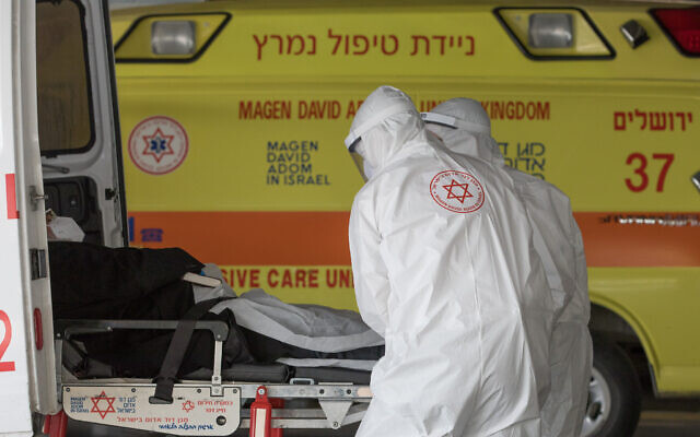 Photo d'illustration : Des médecins du Magen David Adom avec des combinaisons de protection contre le coronavirus pendant le transfert d'un malade à l'hôpital Shaare Zedek, à Jérusalem, le 6 avril 2020 (Crédit : Nati Shohat/Flash90)