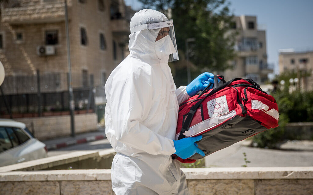 Des employés du Magen David Adom en combinaison de protection contre le coronavirus se rendent chez un malade présumé à Jérusalem, le 14 avril 2020 (Crédit : Yonatan Sindel/Flash90)