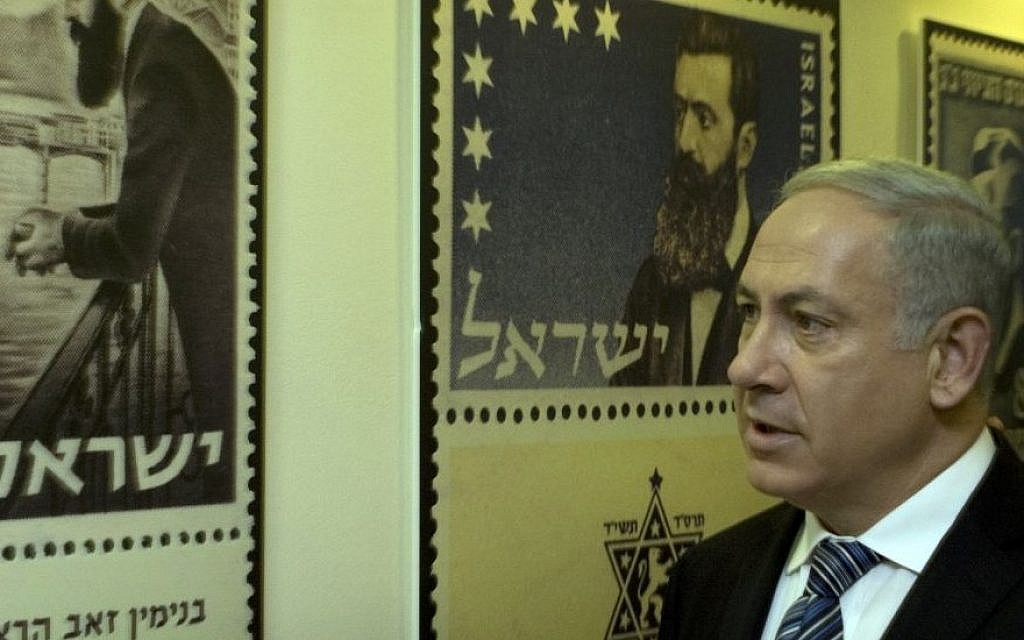 Dans ce dossier photo du 18 avril 2010, le Premier ministre Benjamin Netanyahu regarde des affiches de timbres-poste représentant Theodor Herzl, le fondateur du sionisme moderne, à Jérusalem. (Crédit photo : AP/Sebastian Scheiner)
