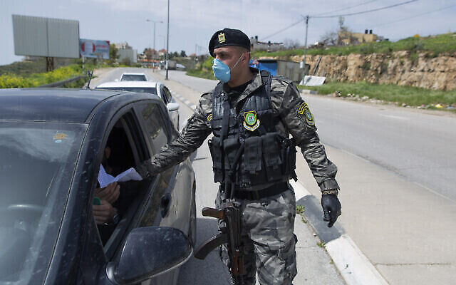 Un agent des forces de sécurité de l'Autorité palestinienne contrôle l'application des règles contre le COVID-19 dans la ville de Ramallah en Cisjordanie, le 23 mars 2020. (AP Photo/ Nasser Nasser)