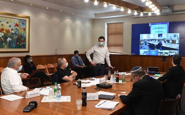 Le ministre de Finances Moshe Kahlon (gauche), le directeur adjoint du ministère de la Santé Moshe Bar Siman-Tov (debout) et d'autres officiels se rencontrent jeudi pour discuter de l'assouplissement des mesures de distanciation sociale mises en place pour lutter contre le coronavirus. (Bureau du Premier ministre)