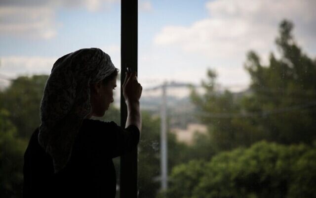 Une Juive orthodoxe regarde par la fenêtre d'un foyer pour femmes battues à Beit Shemesh, le 15 juillet 2014. (Crédit : Hadas Parush/Flash90)