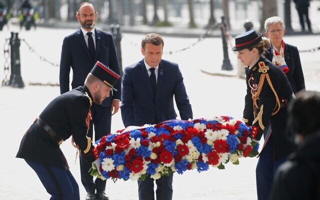 Le président français Emmanuel Macron dépose une couronne de fleurs lors d'une cérémonie marquant la fin de la Seconde Guerre mondiale à l'Arc de Triomphe à Paris le 8 mai 2020. (Crédit : CHARLES PLATIAU / POOL / AFP)