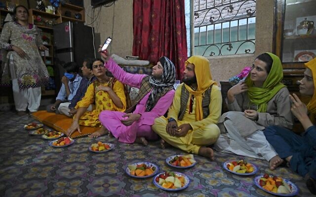 Dans cette photo du 9 mai 2020, des membres de la communauté transgenre se rassemblent pour rompre le jeûne lors du mois islamique sacré du Ramadan à la maison d'un Guru transgenre 
à Rawalpindi. (Photo par Aamir QURESHI / AFP)