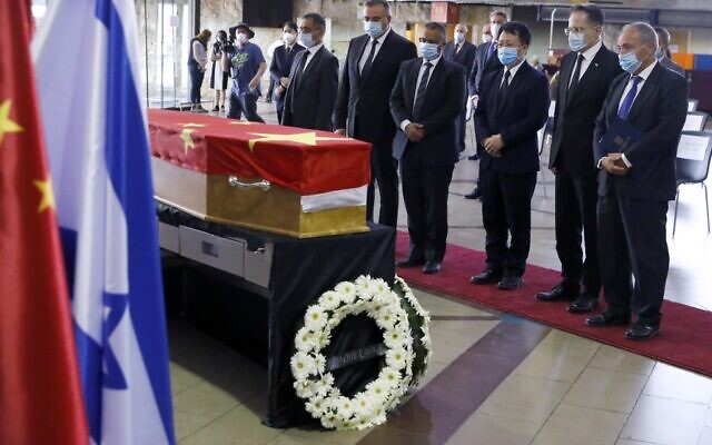 Des officiels chinois rendent hommage à la dépouille de l'ambassadeur chinois Du Wei dans un cercueil recouvert d'un drapeau, lors d'une cérémonie à l'aéroport international Ben Gurion à proximité de Tel Aviv, le 20 mai 2020. (Photo par JACK GUEZ / AFP)
