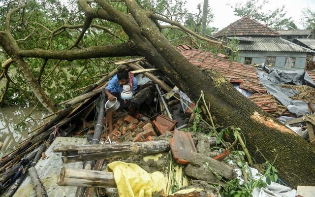 Un homme récupère des objets de sa maison endommagée par le cyclone Amphan à Midnapore, au Bengale occidental, le 21 mai 2020. (Crédit : Dibyangshu SARKAR / AFP)