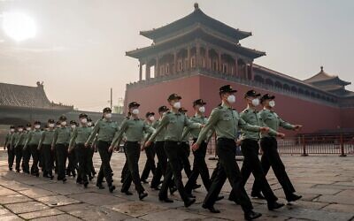 Des soldats de l'Armée populaire de libération défilent devant l'entrée de la Cité interdite lors de la cérémonie d'ouverture de la Conférence consultative politique du peuple chinois (CCPPC) à Pékin, le 21 mai 2020. (Crédit : NICOLAS ASFOURI / AFP)