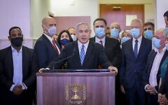 Le Premier ministre Benjamin Netanyahu fait une déclaration avant d'entrer dans une salle d'audience du tribunal de district de Jérusalem le 24 mai 2020, pour le début de son procès pour corruption. Parmi ceux qui l'accompagnent à partir de la gauche, on trouve les députés du Likud et les ministres Gadi Yevarkan, Amir Ohana, Miri Regev, Nir Barkat, Israel Katz, Tzachi Hanegbi, Yoav Gallant et David Amsalem. (Yonathan SINDEL / POOL / AFP)