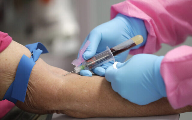 Un travailleur de santé prélève du sang sur un malade pour un test d'anticorps à la COVID-19 au Volusia County Fairgrounds de DeLand, en Floride, le 5 mai 2020. (Crédit : AP Photo/John Raoux)