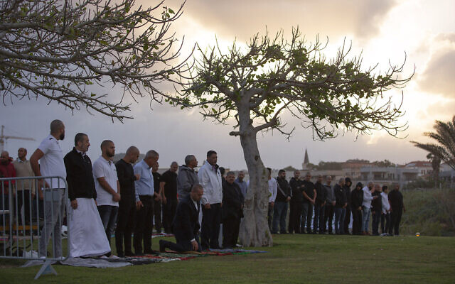 Les fidèles musulmans font la prière de l'Aïd al-Firt qui marque la fin du ramadan dans un parc de la ville de Jaffa, près de Tel Aviv, le 24 mai 2020 (Crédit : AP Photo/Oded Balilty)