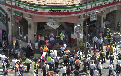 La police et les médecins entourent la scène d'un attentat suicide à la bombe à l'intérieur du restaurant Sbarro de Jérusalem, le 9 août 2001. Quinze personnes ont été tuées et 130 blessées. (AP Photo/Peter Dejong)