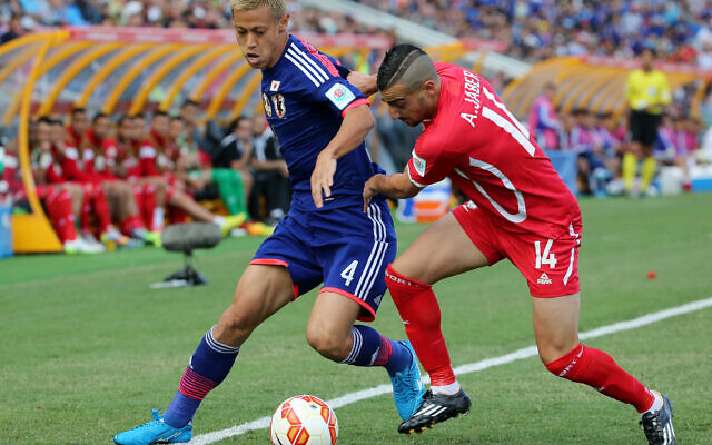 Le Japonais Keisuke Honda, à gauche, et le Palestinien Abdallah Jaber se disputent le ballon lors du match de la Coupe d'Asie de l'AFC entre le Japon et la Palestine à Newcastle, en Australie, le 12 janvier 2014. (Crédit : Rob Griffith/AP)