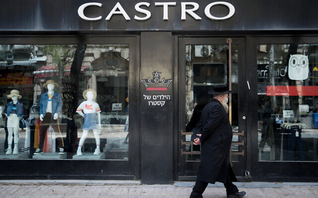 Illustration : Un homme passe devant une succursale fermée de la chaîne de mode Castro dans le centre-ville de Jérusalem le 26 avril 2020. (Crédit : Yonatan Sindel/Flash90)