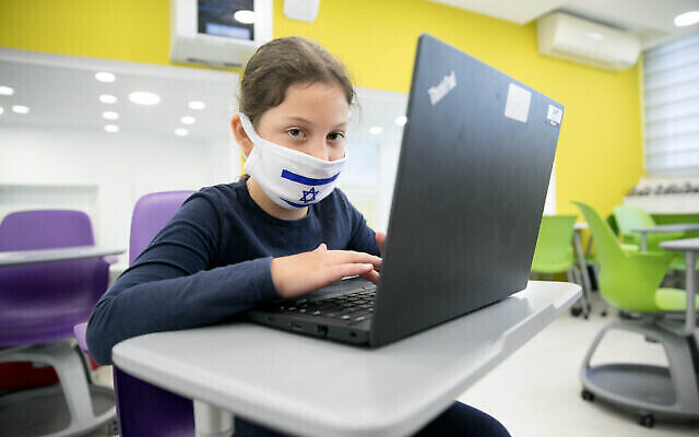 Une élève porte un masque de protection alors que les élèves depuis le cours préparatoire jusqu'au CE2 sont retournés à l'école pour la première fois depuis l'apparition du coronavirus, le 3 mai 2020. (Olivier Fitoussi/Flash90)