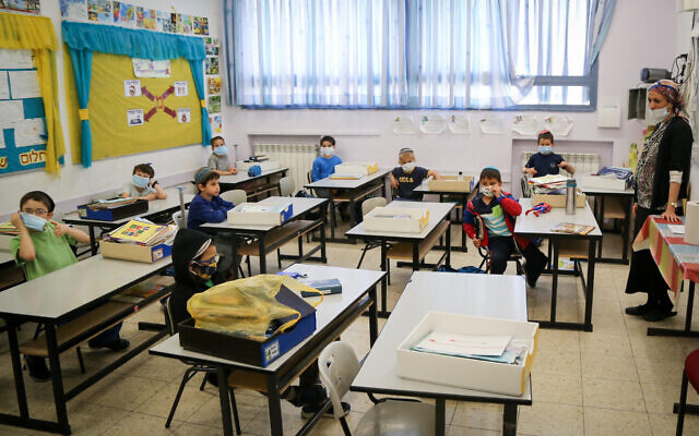 Des élèves israéliens à l'école Orot Etzion à Efrat portent des masques alors qu'ils reviennent à l'école pour la première fois depuis le début de l'épidémie de coronavirus, le 3 mai 2020. (Gershon Elinon/Flash90)