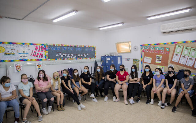 Des élèves et enseignants portent des masques de protection alors qu'ils retournent en classe, à l'école Hashalom à Mevaseret Zion, à proximité de Jérusalem, le 17 mai 2020. (Yonatan Sindel/Flash90)
