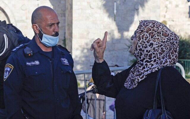 Une Palestinienne se querelle avec un membre des forces de sécurité israéliennes lors d'une manifestation organisée à la porte de Damas, dans la Vieille ville de Jérusalem, un lendemain de la mort d'Iyad Hala, un autiste palestinien abattu par les policiers, le 31 mai 2020 (Crédit : AHMAD GHARABLI / AFP)