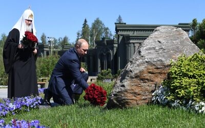 Le président russe Vladimir Poutine, accompagné du patriarche orthodoxe Cyrille de Moscou, dépose des fleurs sur un monument à l'extérieur de la cathédrale des Forces armées dans un parc à thème militaire à l'extérieur de Moscou, le 22 juin 2020. (Crédit : Alexey NIKOLSKY / SPUTNIK / AFP)