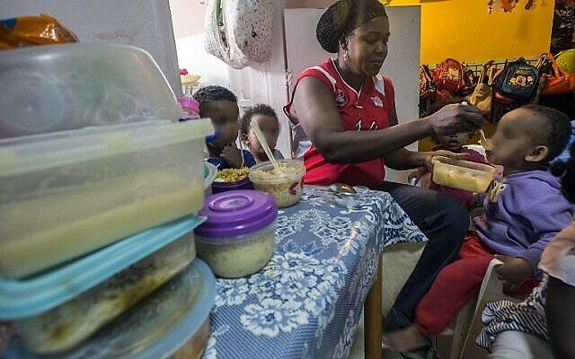Une femme nourrit des enfants de familles d'immigrants africains clandestins dans un centre du sud de Tel Aviv, le 28 mai 2015. Illustration. (Crédit : Jack Guez/AFP)