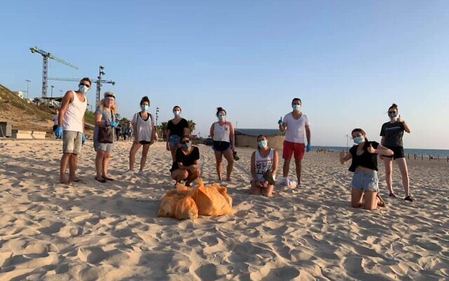 Les volontaires de « Clean Beach » à Tayo Beach, à Bat Yam, lundi 8 juin 2020, à l’occasion de la Journée mondiale des Océans. (Crédit : Arik Shraga-Keren L'Yedidut)