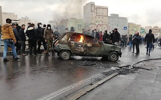 Des manifestants iraniens se rassemblent autour d'une voiture en feu lors d'une manifestation contre l'augmentation du prix de l'essence, dans la capitale Téhéran, le 16 novembre 2019. (AFP)