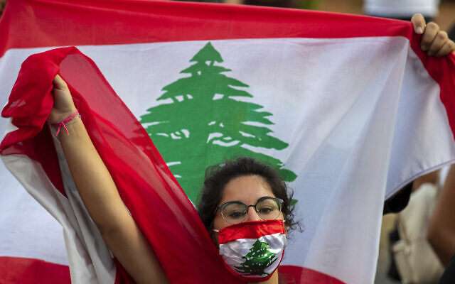 Une manifestante anti-gouvernement crie des slogans en portant un masque aux couleurs du drapeau libanais à Beyrouth, au Liban, le 2 juillet 2020. (Hassan Ammar / AP)