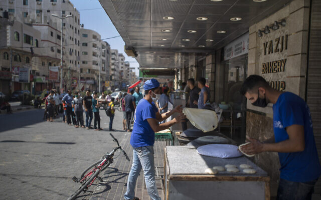 Des Palestiniens font la queue devant une boulangerie pour acheter du pain pendant le blocus de 48 heures imposé suite à la découverte des premiers cas de coronavirus dans la bande de Gaza, le 25 août 2020. (AP/Khalil Hamra)