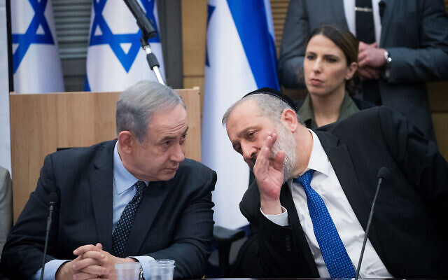 Le Premier ministre Benjamin Netanyahu à gauche, parle avec le président du parti Shas, Aryeh Deri, lors d'une réunion à Jérusalem, le 4 mars 2020. (Crédit: Yonatan Sindel/Flash90)