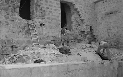 Deux hommes regardent les débris sous les fenêtres brisées de la prison d'Acre, au nord de Haïfa, en Palestine sous mandat britannique, le 6 mai 1947, ouverte à la dynamite deux jours plus tôt par des membres d'une milice juive clandestine. (AP Photo)