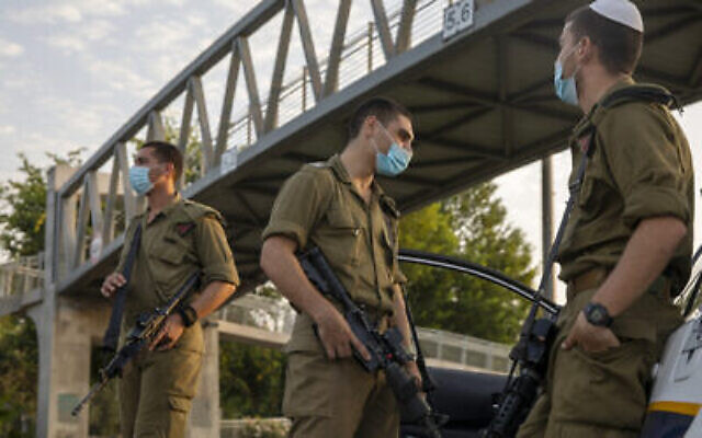 Des soldats israéliens portent des masques faciaux à un barrage routier de la police à Tel Aviv pendant le confinement national en raison de la pandémie de coronavirus, le 19 septembre 2020. (AP Photo / Ariel Schalit)