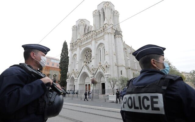 Des policiers français montent la garde sur le site d'une attaque au couteau à la Basilique Notre-Dame de Nice, le 29 octobre 2020. (Crédit : ERIC GAILLARD / AFP)