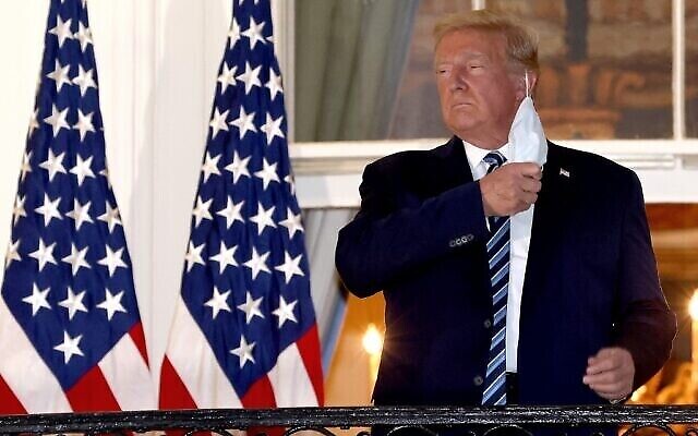 Le président Donald Trump retire son masque à son retour à la Maison Blanche après son hospitalisation pour cause de Covid-19, le 5 octobre 2020 à Washington, DC. (Win McNamee/Getty Images/AFP)