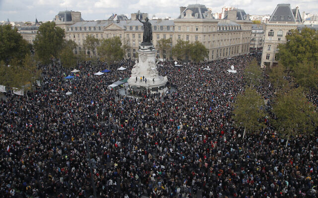 Des centaines de personnes se rassemblent place de la République lors d'une manifestation le 18 octobre 2020 à Paris suite à l'assassinat du professeur Samuel Paty. (Crédit : AP Photo / Michel Euler)