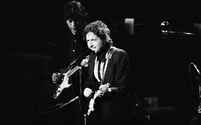 Le chanteur Bob Dylan sur la scène du Madison Square Garden de New York, le 30 janvier 1974, lors de l'une de ses trois apparitions avec The Band à New York. Robbie Robertson, à gauche, accompagne Dylan à la guitare. (Crédit : AP / Ray Stubblebine)