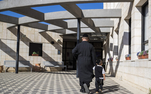 Photo d'illustration : Un ultra-orthodoxe accompagne son petit garçon à l'école Poalei Menahem Talmud Torah dans l'implantation de Beitar Illit, en Cisjordanie, le 4 septembre 2016. (Crédit :  Nati Shohat/Flash90)