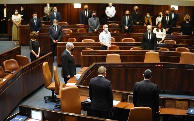 Les membres de la Knesset observent une minute de silence lors d'une session plénière pour marquer les 25 ans de l'assassinat du Premier ministre Yitzhak Rabin, le 29 octobre 2020. (Shmulik Grossman/Knesset)