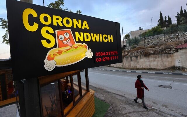 Une femme passe devant le restaurant "Corona Sandwich" à Bethléem, en Cisjordanie , qui appartient à un ancien guide touristique palestinien, le 6 novembre 2020. (Crédit : Emmanuel DUNAND / AFP)