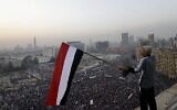 Un Égyptien agite un drapeau national au-dessus d'un rassemblement pro-militaire marquant le troisième anniversaire du soulèvement de 2011 sur la place Tahrir au Caire, en Égypte, le samedi 25 janvier 2014. (AP/Amr Nabil/File)