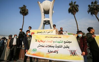 Des jeunes d'un groupe se faisant appeler "Tajammu' Shabab al-Sharia" (Rassemblement des jeunes pour la Sharia) brandissent une banderole condamnant les magasins d'alcool et les maisons closes lors d'une manifestation à Bagdad, la capitale irakienne, le 3 décembre 2020, pour exiger la fermeture des boîtes de nuit et des ventes de boissons alcoolisées. (Crédit : AHMAD AL-RUBAYE / AFP)