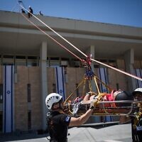 Des membres de la garde d'honneur de la Knesset, du Commandement du Front intérieur, des pompiers, de l’armée, de la police israélienne et du service de secours du Magen David Adom participant à un exercice d'urgence simulant un tremblement de terre à la Knesset, à Jérusalem, le 13 juin 2017. (Crédit : Hadas Parush/Flash90)