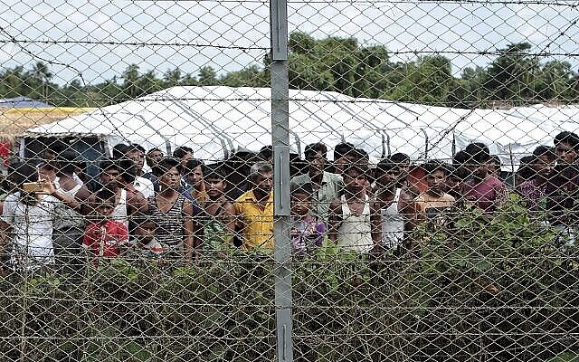 Sur cette photo du 29 juin 2018, des réfugiés rohingyas se rassemblent près d'une clôture lors d'une tournée médiatique organisée par le gouvernement, dans le no man’s land entre le Myanmar et le Bangladesh, près du village de Taungpyolatyar, Maung Daw, dans le nord de l'État de Rakhine, au Myanmar. (Photo AP / Min Kyi Thein)