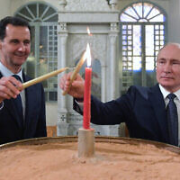 Le président russe Vladimir Poutine, (à droite), et le président syrien Bashar el-Assad allument des bougies lors de leur visite d'une cathédrale orthodoxe pour Noël, à Damas, en Syrie, le 7 janvier 2020. (Alexei Druzhinin, Spoutnik, Kremlin Pool Photo via AP)