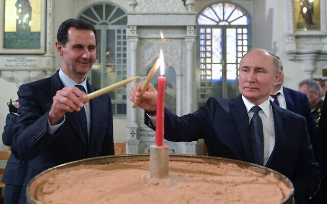 Le président russe Vladimir Poutine (à droite) et le président syrien Bashar el-Assad allument des bougies lors de leur visite d'une cathédrale orthodoxe pour Noël, à Damas, en Syrie, le 7 janvier 2020. (Crédit : Alexei Druzhinin, Spoutnik, Kremlin Pool Photo via AP)